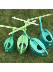 Zelen� plastova zalievacia li�ta nasaden� na r�zne ve�k�ch krhl�ch.